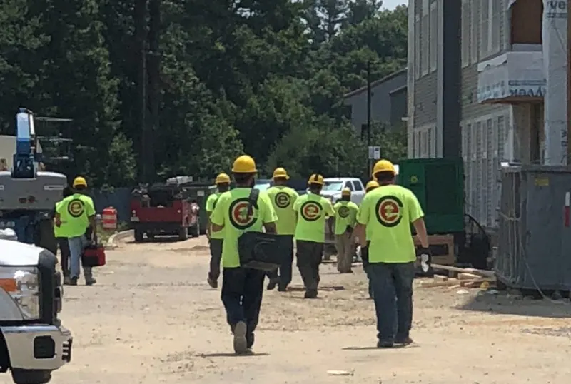 CES crew in high-visibility shirts walking onto a job site