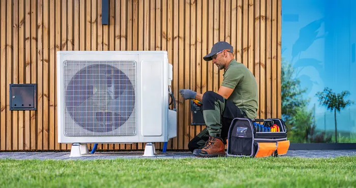 Technician servicing an outdoor heat pump